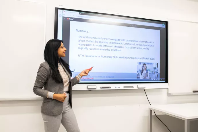 An instructor presenting a slideshow on a SmartBoard.