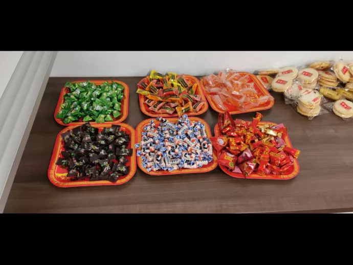 Six red trays contain different kinds of New year snacks