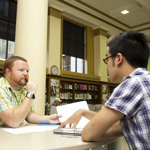 Student speaking with a career advisor within a library