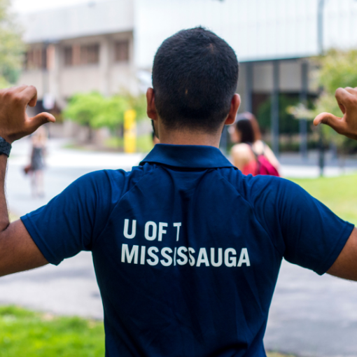 Student point at their UTM T-shirt outside of Kaneff