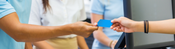 A person is handing a blue card to another person.