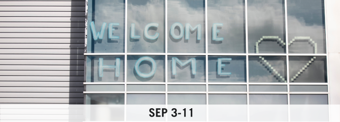 "Welcome Home" written on a residence building window.