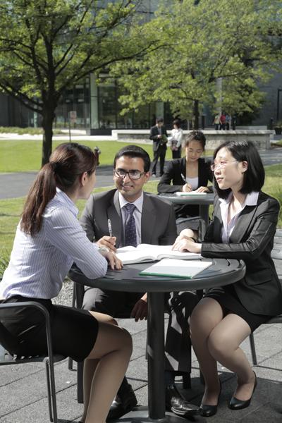 (l-r) Kelsey Song, Adeel Yousufani and Jessica Lin sit at table outside