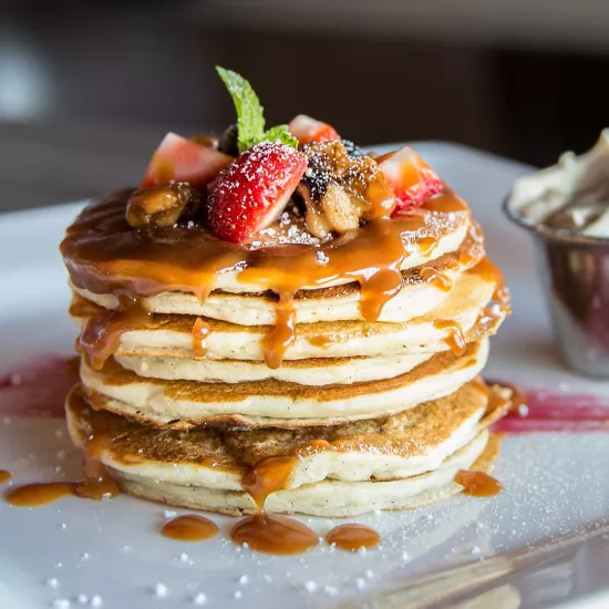 Pancakes with maple syrup and strawberries on the top