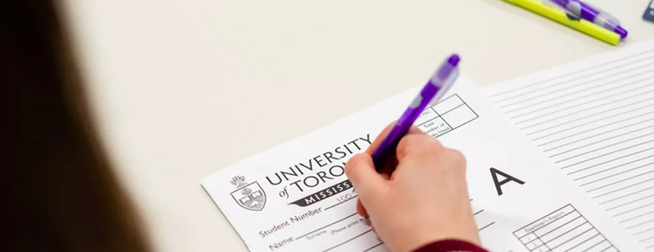 Photo of a student writing filling out their exam booklet