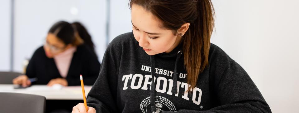 Student wearing a U of T sweater is writing a multiple choice exam