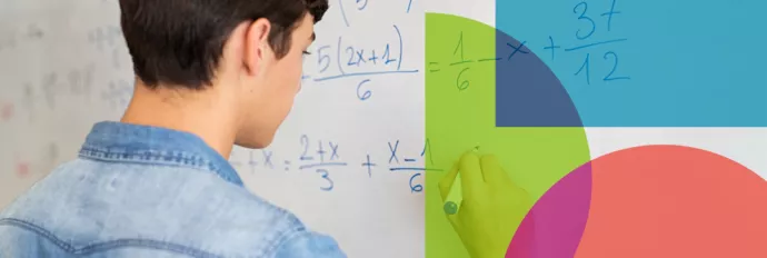 A student standing at a white board working on a math equation