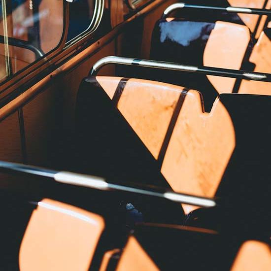 Empty seats on a bus during the daytime. Photo by Dan Gold on Unsplash