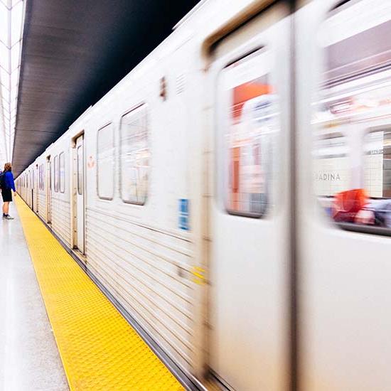TTC subway in motion, with people waiting on the platform. Photo by Jed Dela Cruz on Unsplash