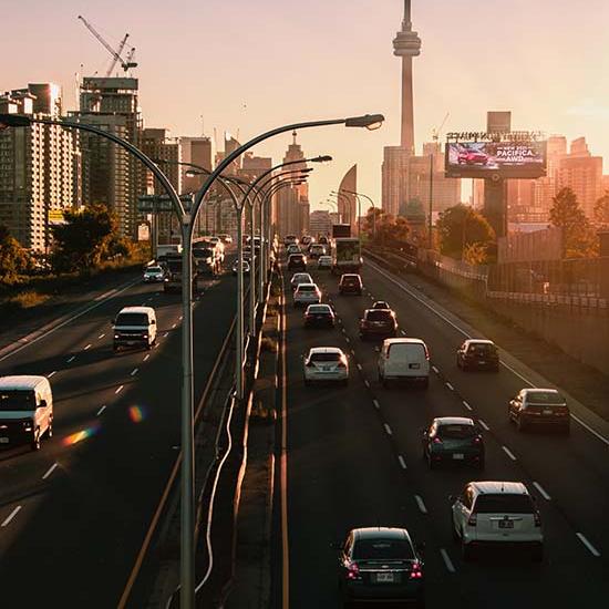 Toronto highway with cars at sunrise. Photo by Lianhao Qu on Unsplash