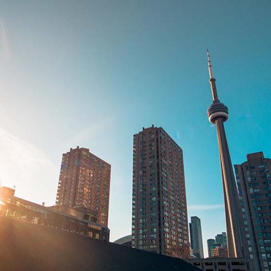 Toronto's CN Tower and skyscrapers against a blue sky. Image by Warren Wong on Unsplash