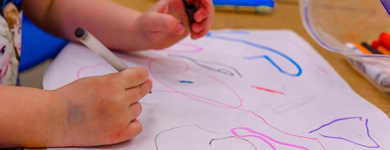 Child colouring a piece of paper