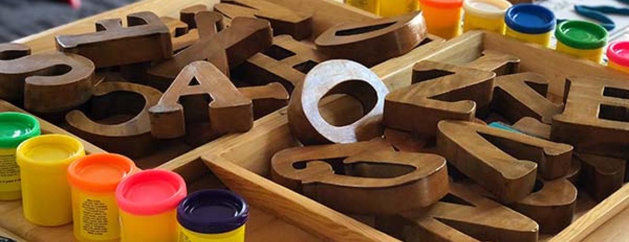 Wooden alphabet blocks on a table in a daycare setting