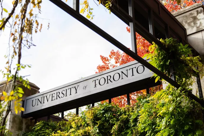 Sign that reads University of Toronto, green foliage below sign