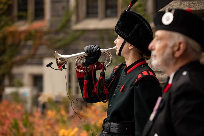 Woman in black and red uniform plays a trumpet