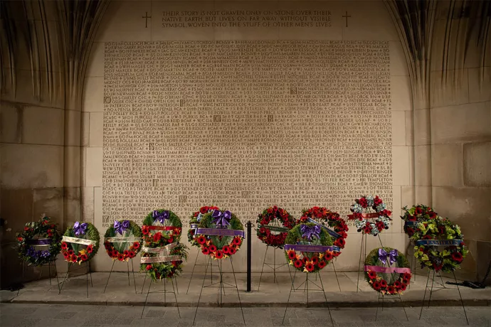 Row of wreaths in front of stone wall