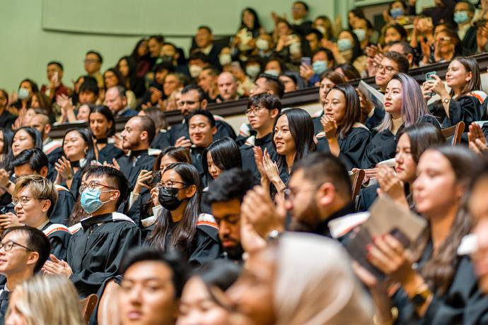 A large group of people in seats wearing grad gowns