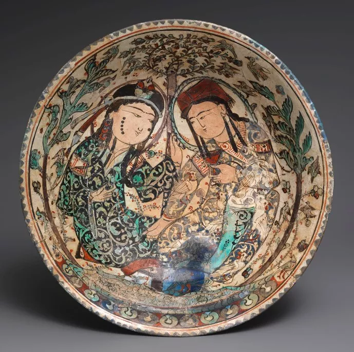 Round painted plate with two figures, a man and woman, facing one another.