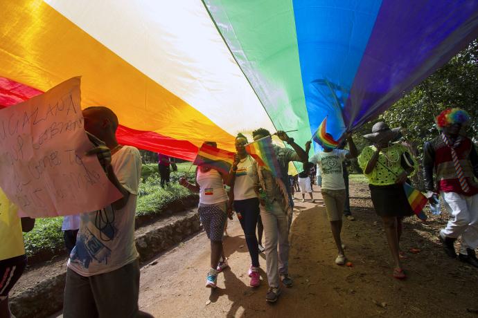 Activists march with a rainbow flag during a Pride rally in Uganda in 2015