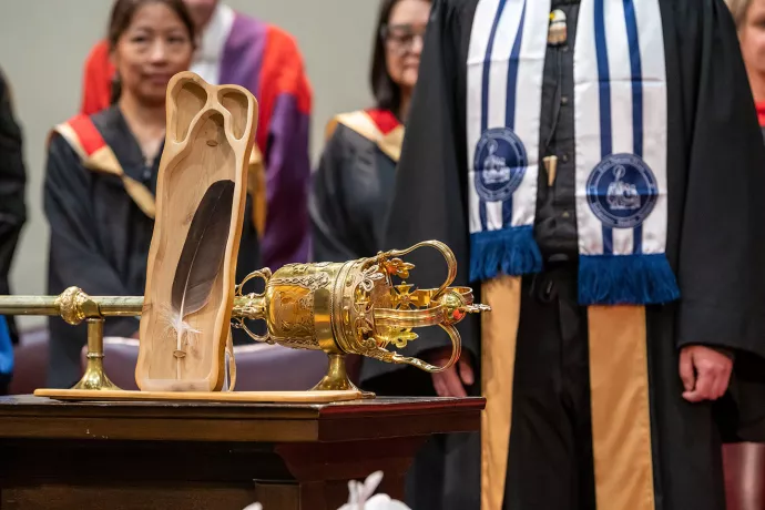 Close up of the ceremonial Eagle Feather in front of the ceremonial mace used during convocation