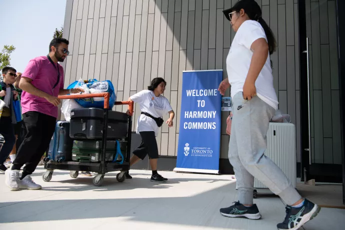 Students move a cart with their belongings into Harmony Commons.