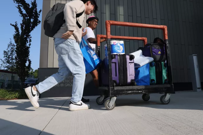 Students move a cart loaded with their belongings.