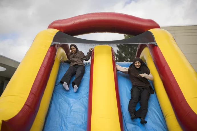 students slide down an inflatable slide