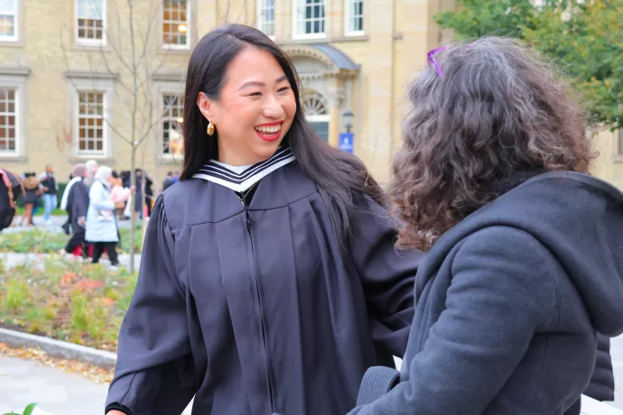 A UTM grad laughs outside Convocation Hall after the fall 2023 convocation ceremony