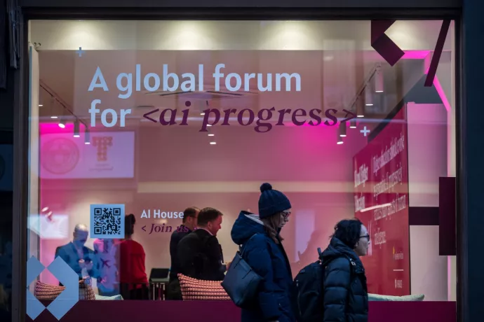 people walk by a booth dedicated to AI at the 2024 World Economic Forum in Switzerland.