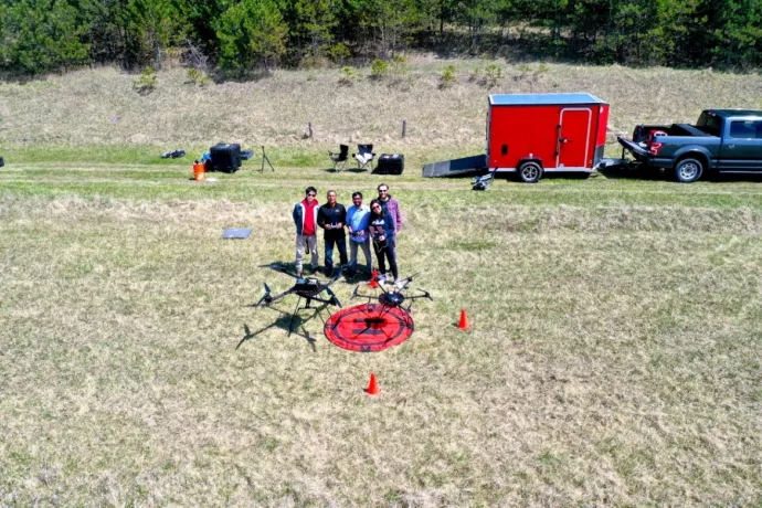 Group photo of researchers in a clearing with drone equipment