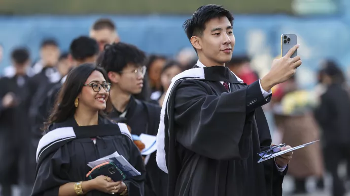 A University of Toronto Mississauga graduate takes a photo as they enter Convocation Hall ahead of fall convocation ceremonies at the University of Toronto on Wednesday, October 29, 2025. 