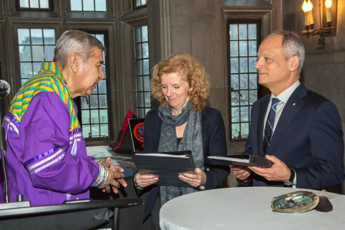 Elder Andrew Wesley (left) presents U of T’s Truth and Reconciliation Steering Committee's final report to Provost Cheryl Regehr (centre) and President Meric Gertler