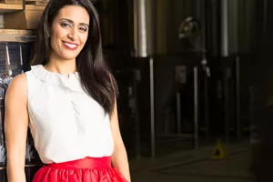 Manjit Minhas in a white shirt and red skirt