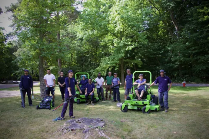 Grounds team members pose outside with new equipment.