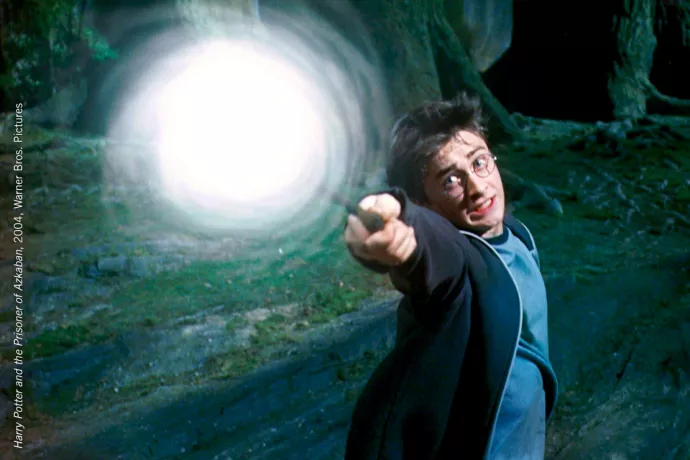 Movie still showing frightened Harry Potter casting a spell. The tip of his wand is engulfed in a swirling white light.