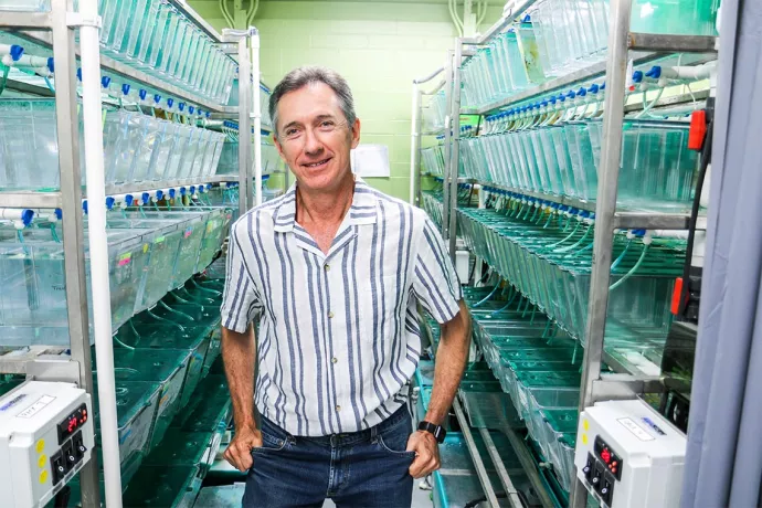 Robert Gerlai standing by tanks of fish in his lab