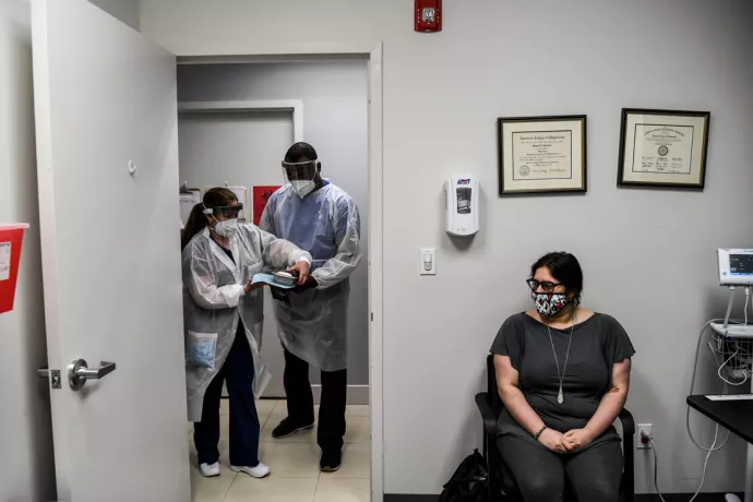 A masked volunteer awaits vaccination with a trial version of the COVID-19 vaccine.