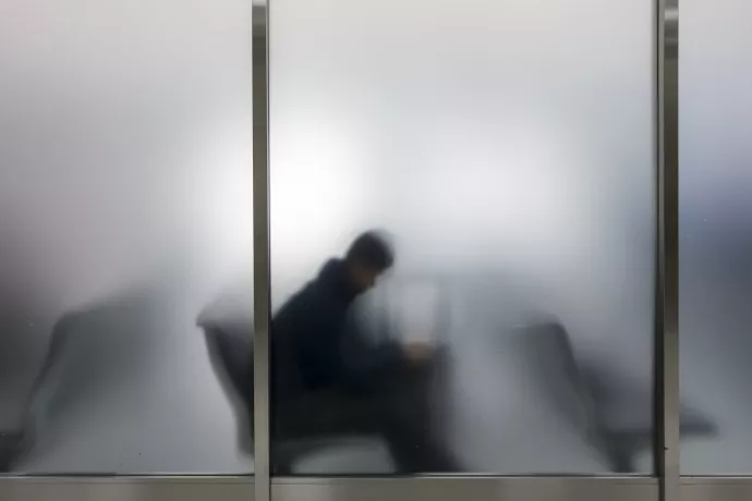 man sitting behind a semi-opaque window