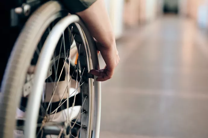 Close up of wheelchair wheel with hand on it