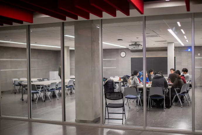 students studying in a room with concrete and glass walls
