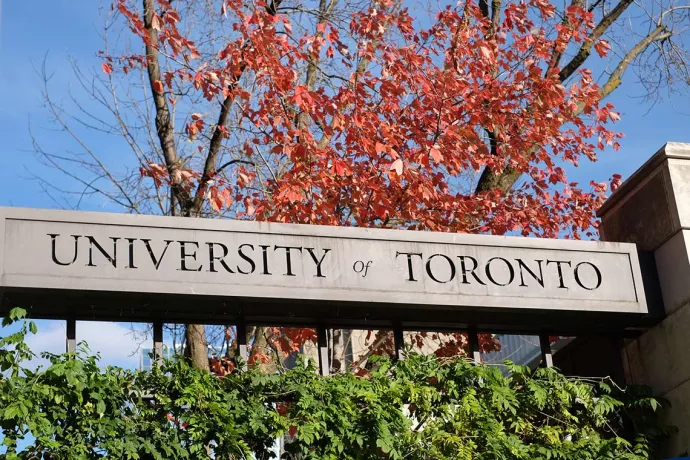 U of T stone gate sign with autumn leaves