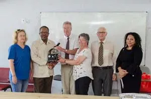 Professor Dan Schulze, centre, presents microscopes to the University of Guyana