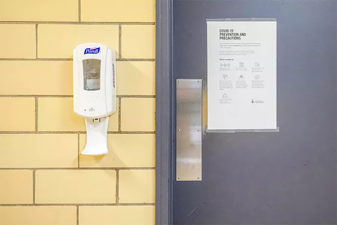 Hand sanitizer station on wall next to door