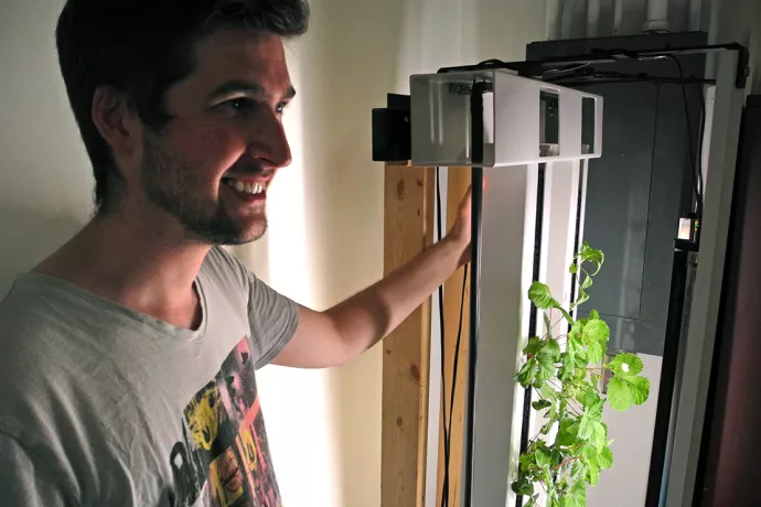 Conner Tidd standing next to lettuce growing vertically