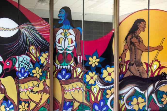 Colourful mural on glass panels that show stylized fish, bears, two humanoids and a wolf.