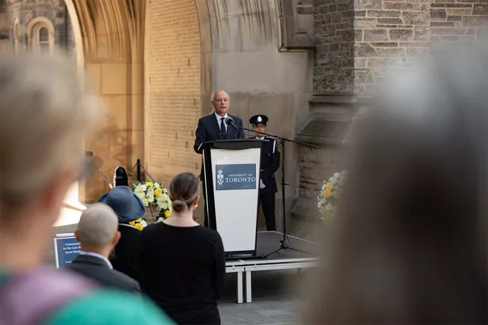 U of T President Meric Gertler stands at a podium addressing a crowd.