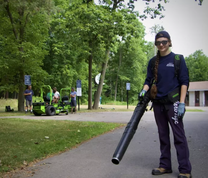 Grounds team member holds a leafblower