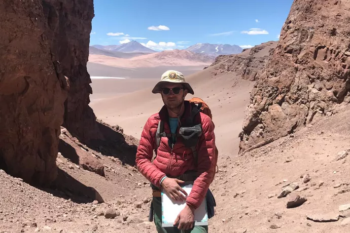 Mitchell McMillan stands in the rocky red landscape of the Salina del Fraile.