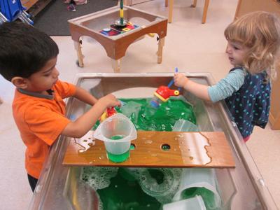 boy and girl playing at water table