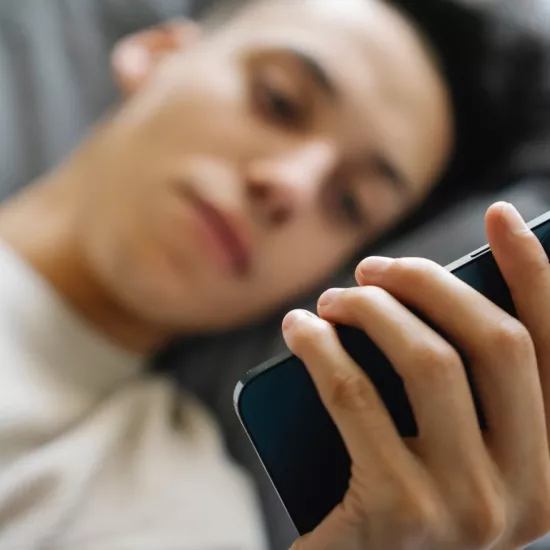 person using smartphone in bed